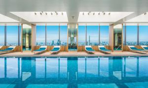 a hotel pool with chairs and a view of the city at The Prince Gallery Tokyo Kioicho, a Luxury Collection Hotel in Tokyo