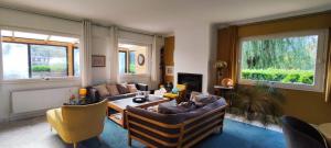 a living room with a couch and a table at Tamaris, Villa avec très grand jardin in Cucq