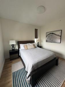 a bedroom with a bed and two lamps and a rug at Downtown Traverse City Capri Condo 316 in Traverse City
