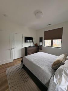 a bedroom with a bed and a flat screen tv at Downtown Traverse City Capri Condo 316 in Traverse City +49 photos