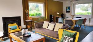 a living room with a couch and a table at Tamaris, Villa avec très grand jardin in Cucq