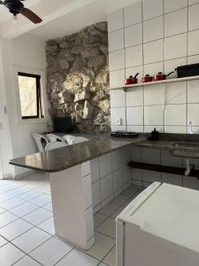 una cucina con bancone e parete in pietra di Pousada Porto da Barra Praia a Porto Seguro