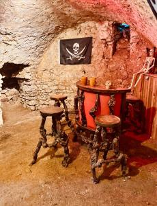 a table and two stools in a stone room at Logement insolite La cachette des Pirates, Jacuzzi, ciné et pop corn in Montreuil-sur-Thérain +17 photos