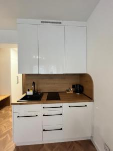 una cucina con mobili bianchi e un lavandino di PLANETA 202 - tylko 100 m do GŁÓWNEGO DEPTAKU i plaży! a Mielno