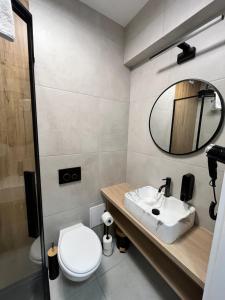 un bagno con un water, un lavandino e uno specchio di PLANETA 202 - tylko 100 m do GŁÓWNEGO DEPTAKU i plaży! a Mielno
