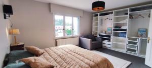 a bedroom with a bed and a chair and a window at Tamaris, Villa avec très grand jardin in Cucq