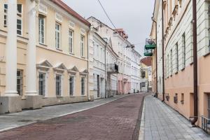 an empty street in a city with buildings at Noble Apartments in Vilnius
