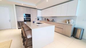 eine Küche mit weißen Schränken und einer weißen Arbeitsplatte in der Unterkunft NEW Amrit Resort Oceanview Retreat in Singer Island