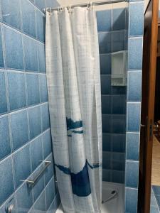 cortina de ducha en el baño con azulejos azules en La Casa di Mia, en Vesime