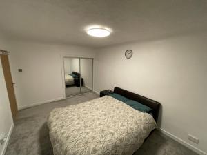 a bedroom with a bed and a clock on the wall at Dein Haus in Tile Hill