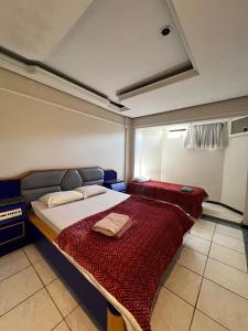ein Schlafzimmer mit einem großen Bett mit einer roten Decke in der Unterkunft Villa do Lago in Poços de Caldas