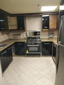 a kitchen with a stove and a refrigerator at Luxury Sea View Apartment in Four Seasons Alexandria in Alexandria