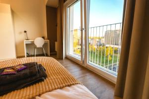 a bedroom with a bed and a large window at Homely! Skyview 2-Room Apartment, Airport, Fair, Rooftop, Gym! in Frankfurt/Main +8 photos