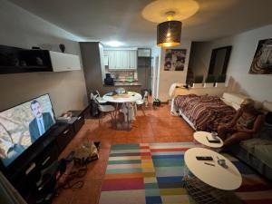 ein Wohnzimmer mit Sofa und Fernseher in der Unterkunft Holiday Home Parque Azul Playa La Arena FREE WIFI in Puerto de Santiago