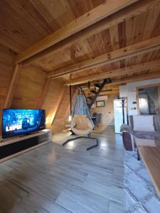 a living room with a flat screen tv and a chair at Greenland in Žabljak