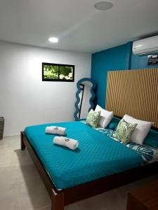 a bedroom with a blue bed with two pillows on it at Casa Hachi in Talamanca