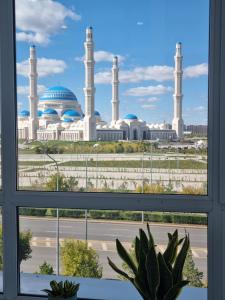 a view of a mosque from a window at Элитные апартаменты в бизнес-комплексе с видом на мечеть in Astana