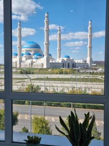 a view of a mosque from a window at Элитные апартаменты в бизнес-комплексе с видом на мечеть in Astana
