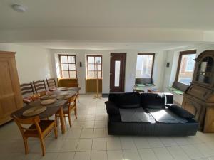 a living room with a couch and a table and chairs at Ferienwohnungen Zum Alten Buchbinder in Guntersblum