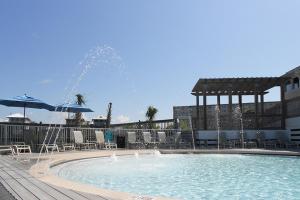 - une piscine avec une fontaine entourée de chaises et de parasols dans l'établissement Just in Time at Destin Pointe, à Destin