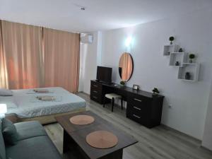 a bedroom with a bed and a table and a mirror at Sarafovo ATLANTIS 58 in Burgas City +65 photos