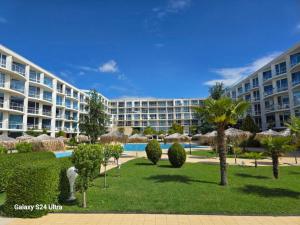 a large apartment building with a yard with trees and bushes at Sarafovo ATLANTIS 58 in Burgas City