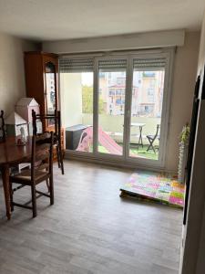 a living room with a table and a window at Appartement T3 - Blue Butterfly in Colomiers +9 photos