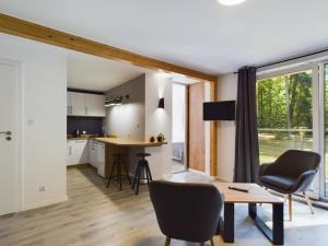 una cucina e un soggiorno con tavolo e sedie di Apartamenty Dabrowka Plus - w lesie, prywatny parking, sauna, park a Jelenia Góra Altre 5 foto