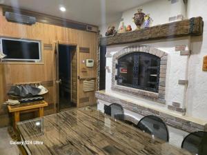a living room with a stone fireplace and a table at Sarafovo ATLANTIS 58 in Burgas