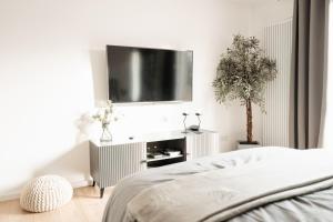 a bedroom with a bed and a flat screen tv at Elegantes Apartment mit Terrasse in Bad Pyrmont