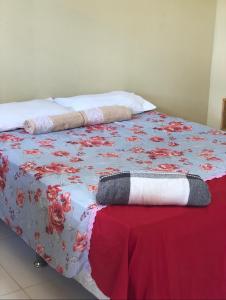 a bed with a red and white blanket on it at Restaurante e Pousada Mandacaru Abacate in Campestre