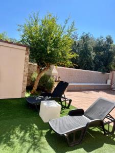 un patio con sillas, una mesa y un árbol en Villa Damare, en Taranto