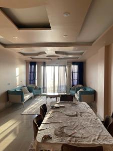 a large room with a table and chairs and a couch at كورنيش نيل in Jazīrat al Badrashayn