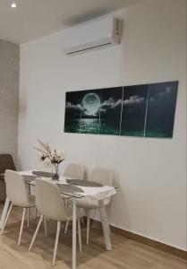 une salle à manger avec une table et des chaises blanches dans l'établissement Apartamentos Luz de Luna B, à Churriana de la Vega