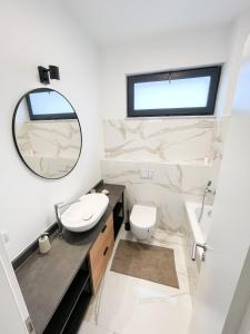 a bathroom with a sink and a toilet and a mirror at Pallady Apartment in Bucharest