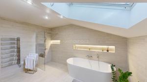 ズリーンにあるVila Kamenecの白い浴槽とシャワー付きのバスルーム