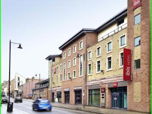 un coche conduciendo por una calle al lado de un edificio en ibis Carlisle City Centre, en Carlisle