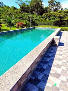 a large swimming pool with a stone bench next to it at Quinta El Futuro in Esperanza