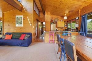 un salon avec un canapé bleu et une table dans l'établissement A Lakeside Story - Lakefront at Okere Falls, à Okere Falls 22 autres photos