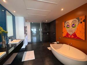 a bathroom with a large tub and a painting on the wall at 3-Bedroom Condo in the romantic zone in Puerto Vallarta