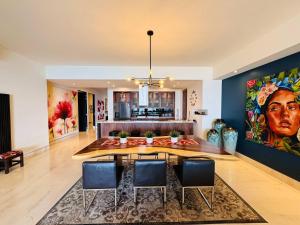a living room with a dining room table with chairs at 3-Bedroom Condo in the romantic zone in Puerto Vallarta
