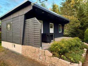 a small black building with a table in it at Ferienhaus im Grünen - Entspannen mit Alpakas in Treuen
