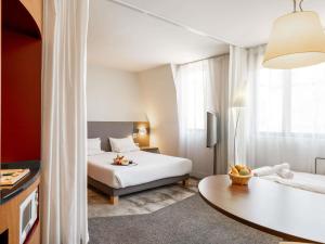 a hotel room with a bed and a table at Novotel Suites Cannes Centre in Cannes +36 photos