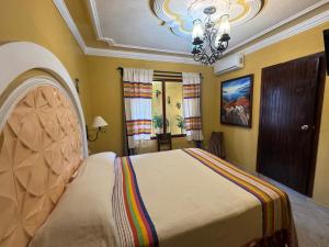 a bedroom with a bed and a chandelier at Hotel Boutique La Casa de María Joyita in Aguascalientes