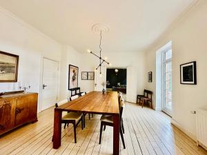 a dining room with a wooden table and chairs at Birkelund1927 in Dannemare +12 photos
