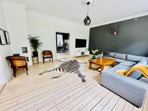 a zebra laying on the floor in a living room at Birkelund1927 in Dannemare