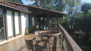 Una terraza con sillas y una fogata en una casa. en Casa Reserva Encantada, en Garopaba