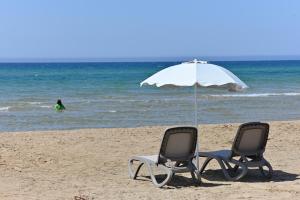 two chairs and an umbrella on the beach at Ristorante Hotel DA VITTORIO in Menfi