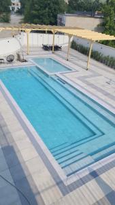 Una gran piscina con dosel y agua azul. en Green apartment Velingrad, en Velingrad