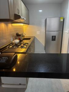 a kitchen with a stove and a refrigerator at PASANI - Casa de Huéspedes in Bucaramanga +6 photos